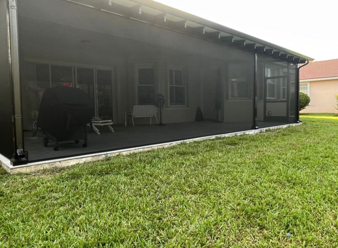 There is a screened in porch in the backyard of a house.