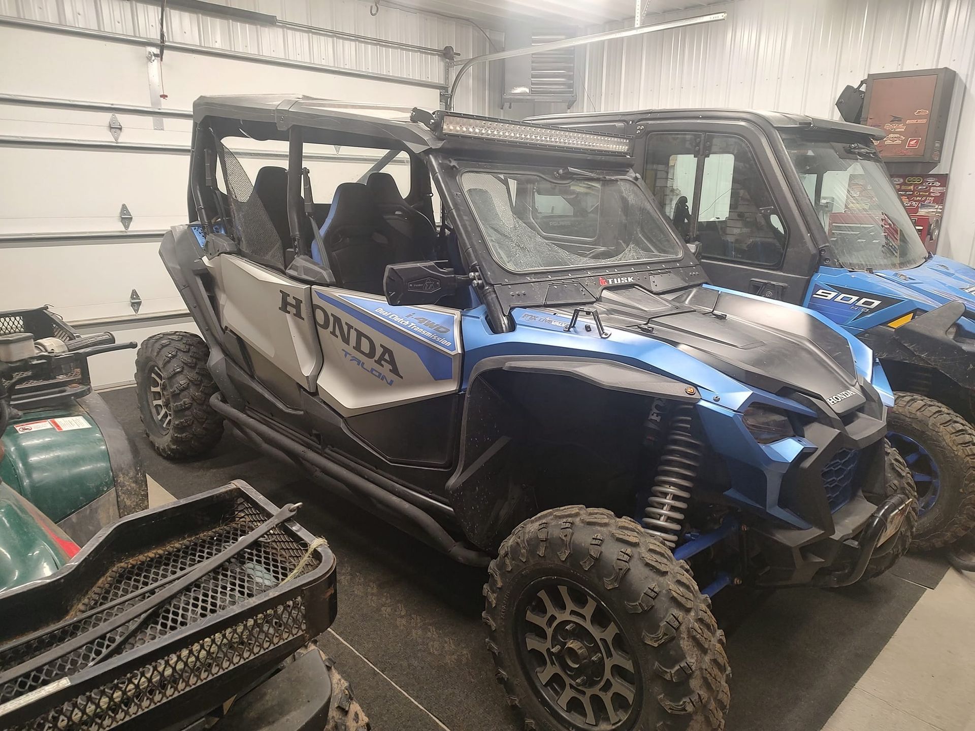 Blue and silver Honda Talon side-by-side vehicle parked in a garage.