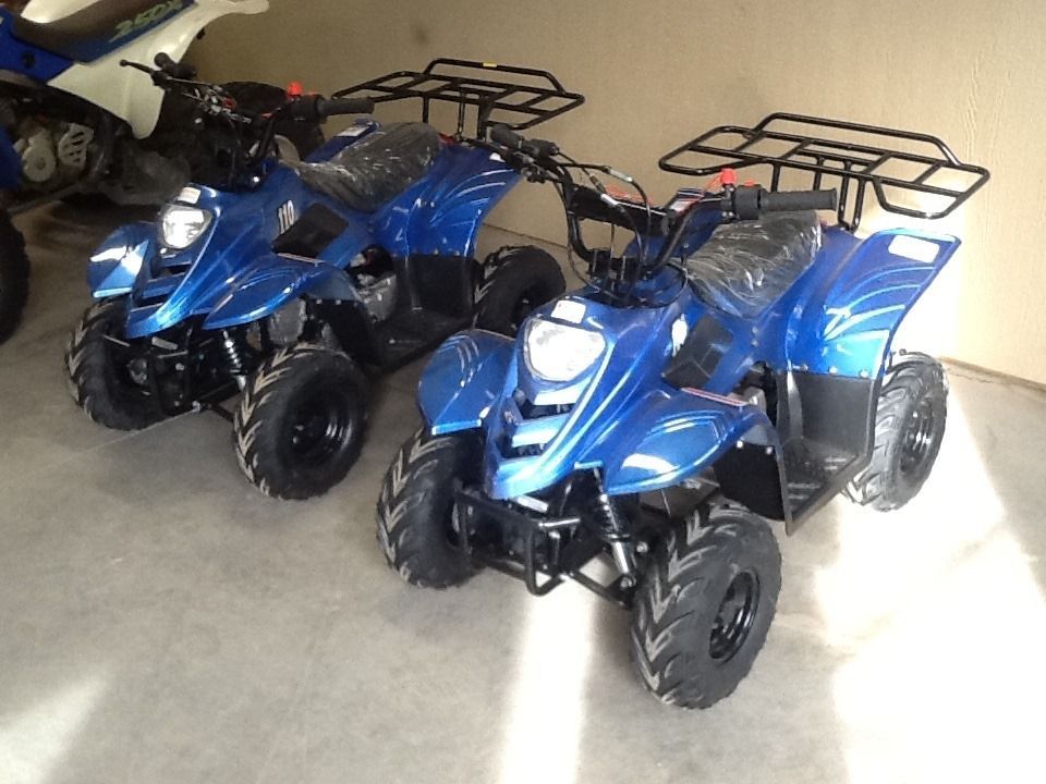 Two blue ATVs parked inside, ready to ride.
