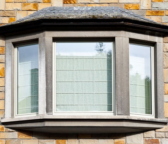 A large bay window on the side of a brick building