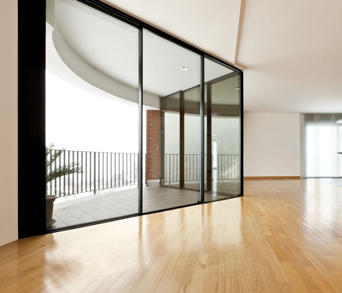 An empty room with sliding glass doors leading to a balcony