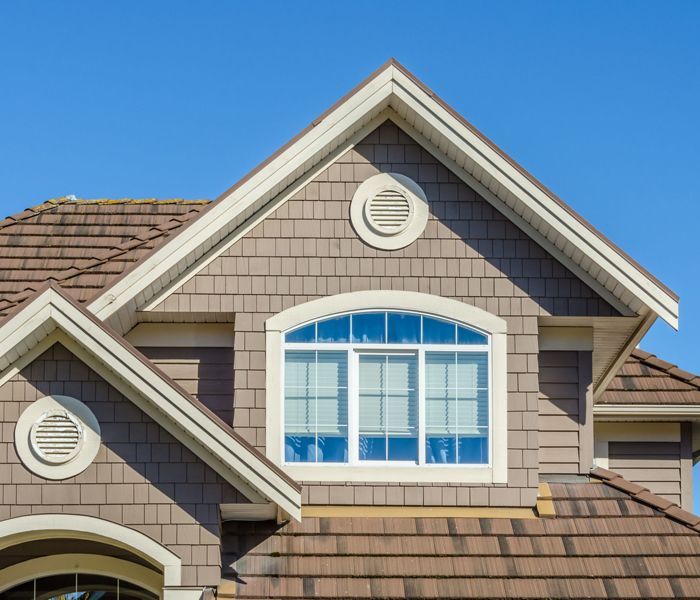 The roof of a house with a large window