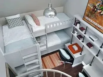 A high-angle view of a compact room featuring a grey bunk bed, a small desk with a chair, and wall-mounted shelving.