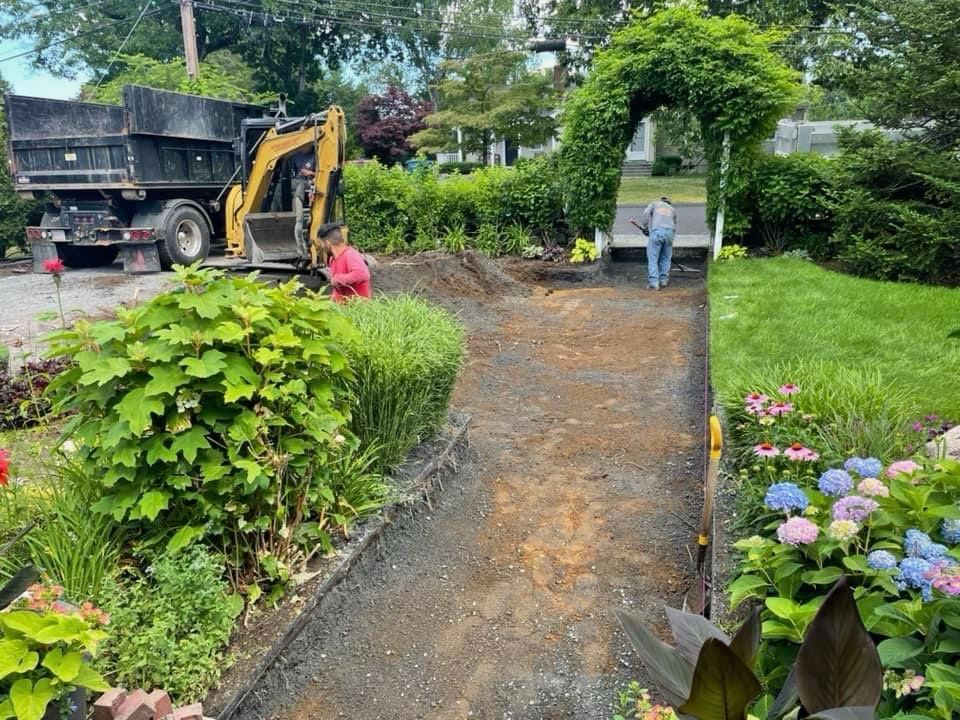 A man is standing next to a dump truck in a garden.