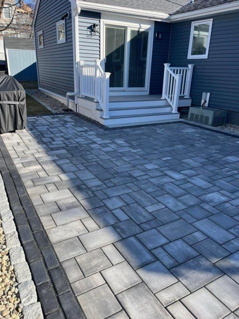 A brick walkway leading to the front of a house.