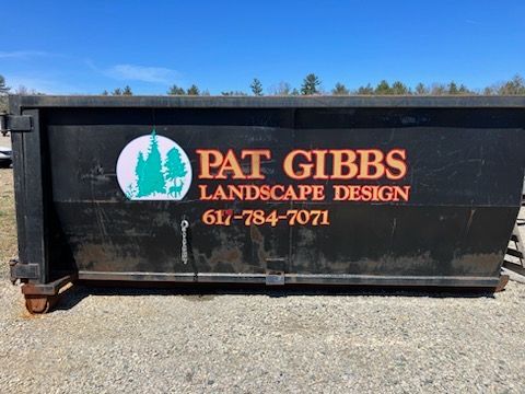A dumpster with pat gibbs landscape design written on it