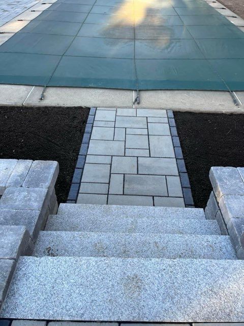 A walkway leading to a pool with a green cover