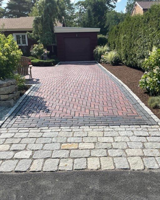 A brick driveway leads to a red garage