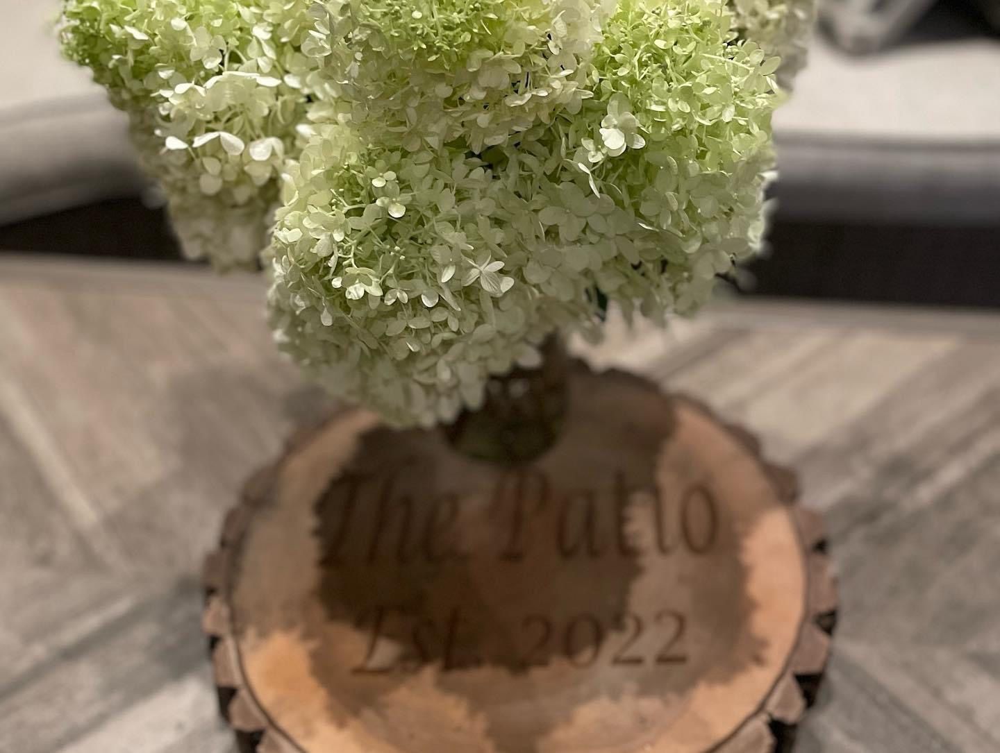A vase of flowers is sitting on top of a wooden block.