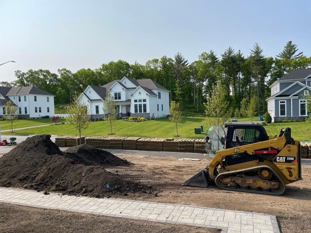A bulldozer is moving dirt on a construction site in a residential area.