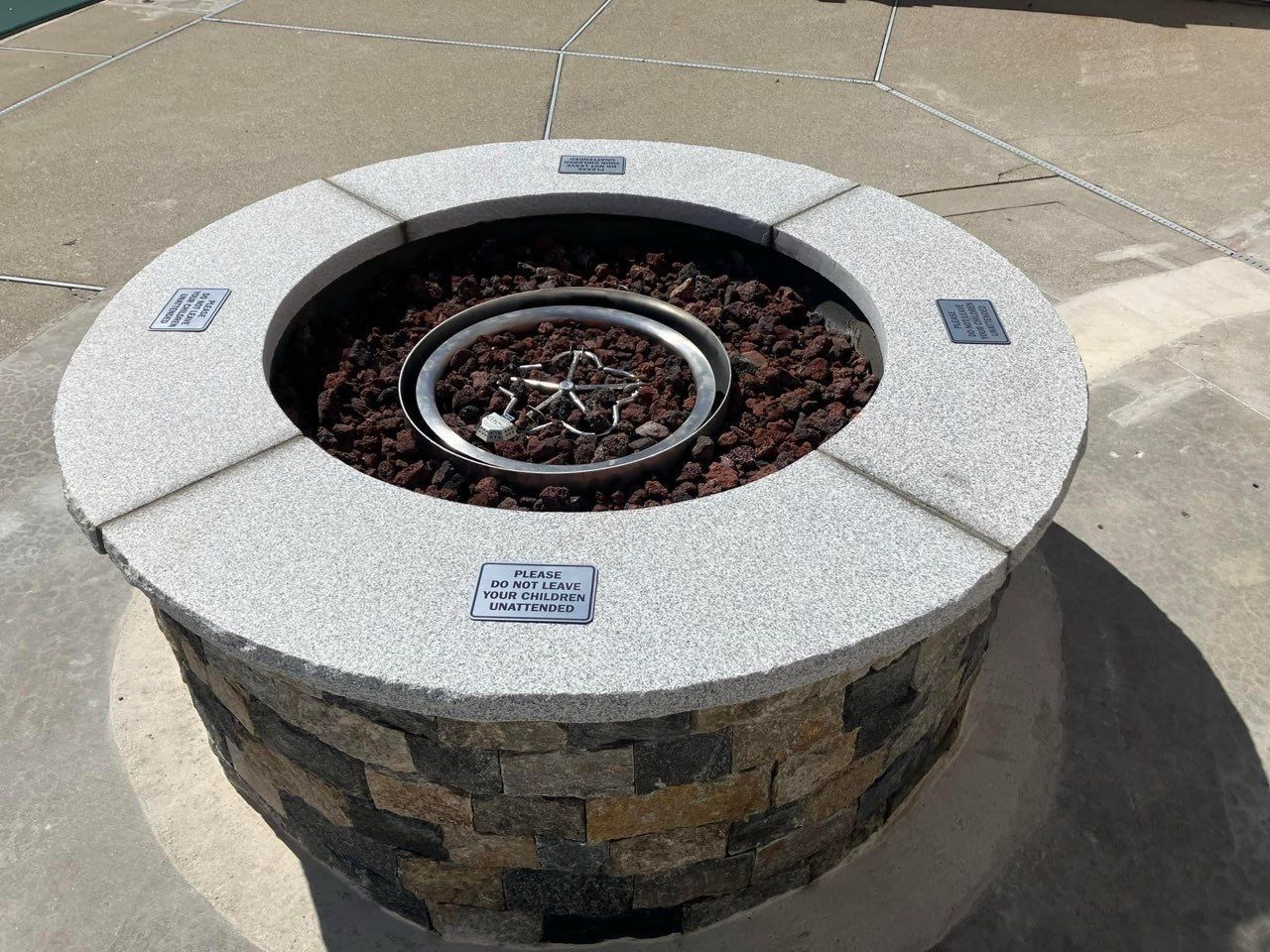 A fire pit sitting on top of a concrete surface