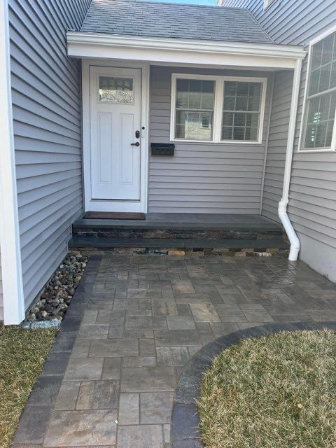 A brick walkway leading to the front door of a house.