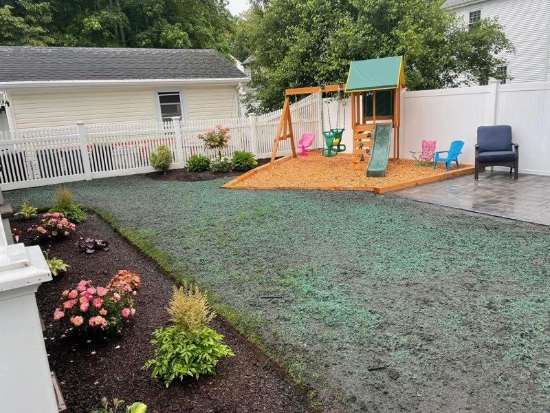 A backyard with a swing set , slide , and chairs.