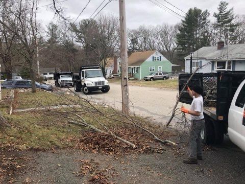 A man is standing next to a truck in a parking lot.