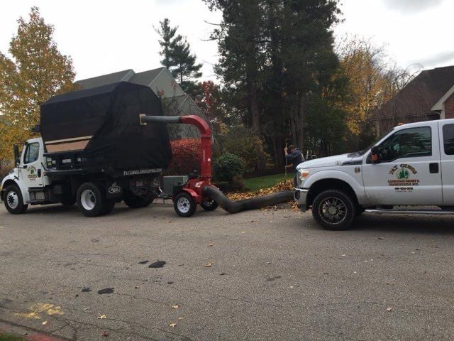 A truck with a leaf vacuum attached to it