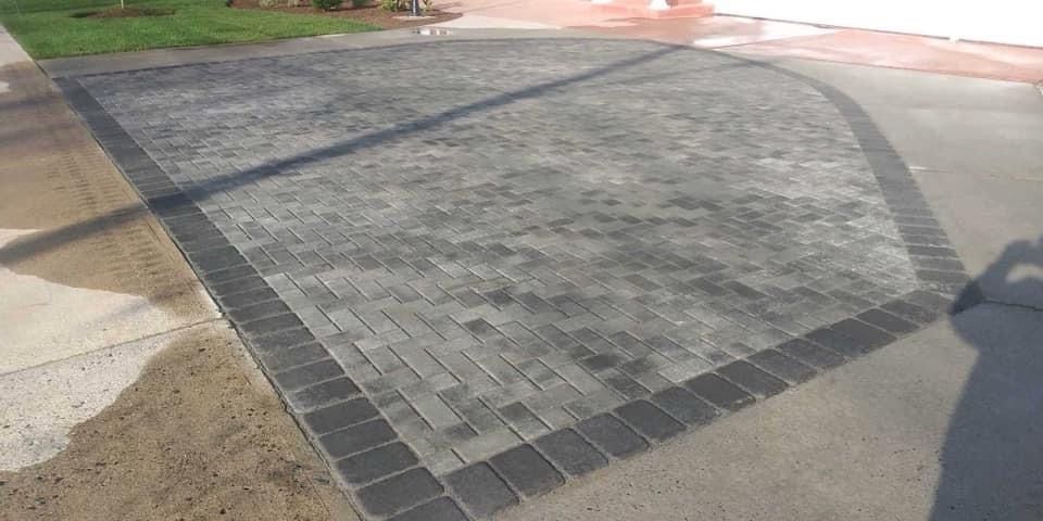 A brick driveway with a shadow of a person on it.