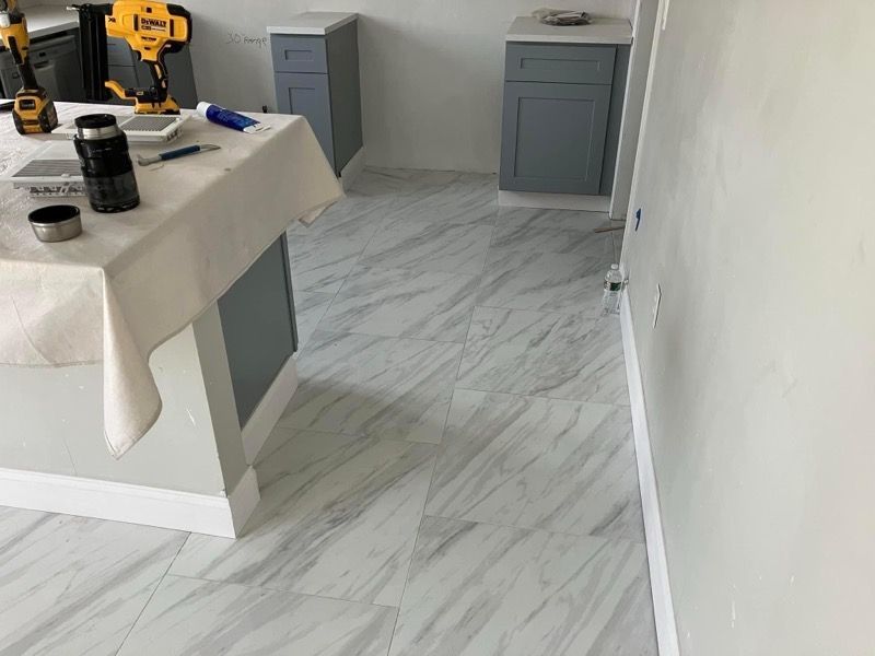 A kitchen with a table and a drill on the floor.