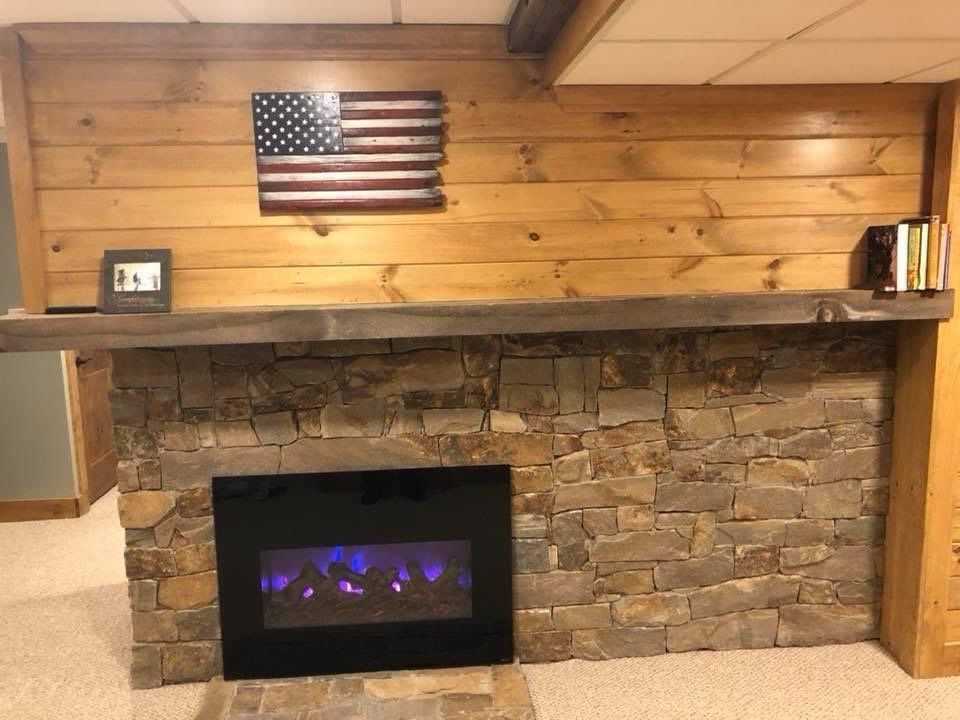A fireplace with an american flag on the wall above it