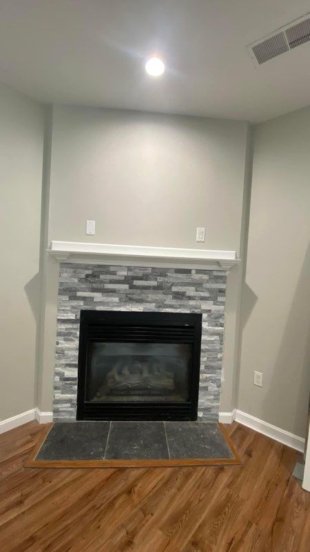 A living room with a fireplace and hardwood floors.