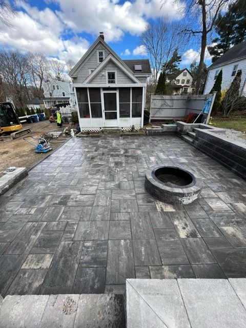 A house with a screened in porch and a fire pit in front of it
