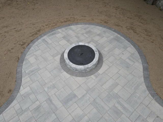 There is a fire pit in the middle of the patio.