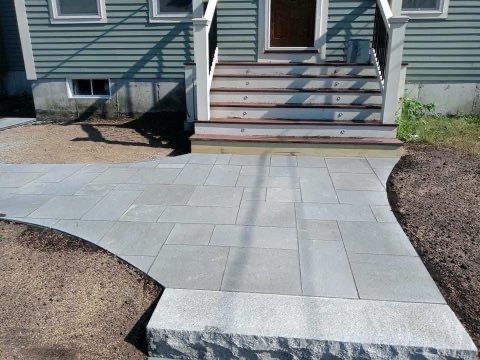 A stone walkway leading to the front door of a house