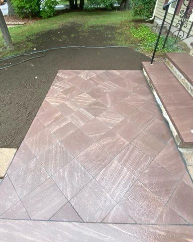 A tiled walkway with stairs leading up to a house.