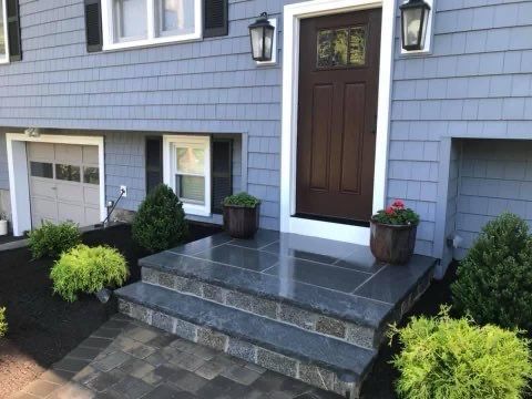 A blue house with a brown door and steps