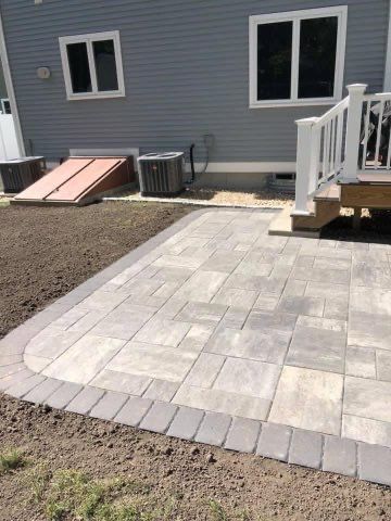 A patio with a white railing is in front of a house.
