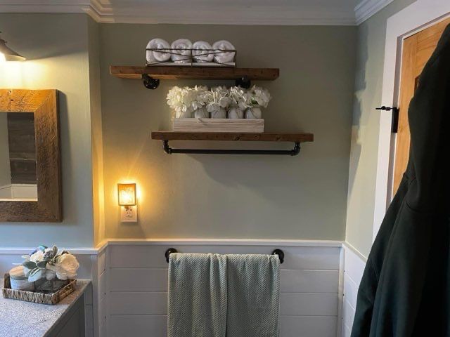 A bathroom with a towel rack and a mirror