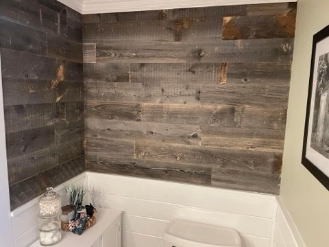 A bathroom with a wooden wall and a toilet.