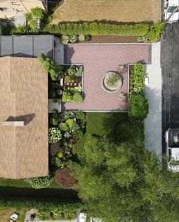 An aerial view of a house with a lot of plants and trees.