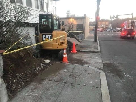 A cat excavator is parked on the side of the road