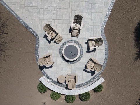 An aerial view of a patio with a fire pit and chairs.