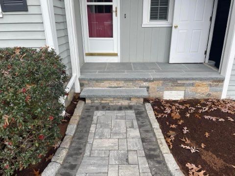 A stone walkway leading to the front door of a house.