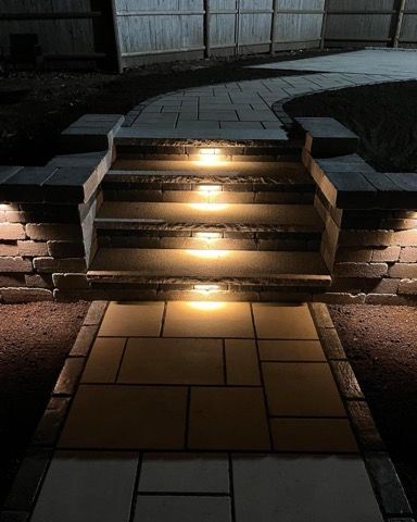 A set of stairs with lights on them at night.