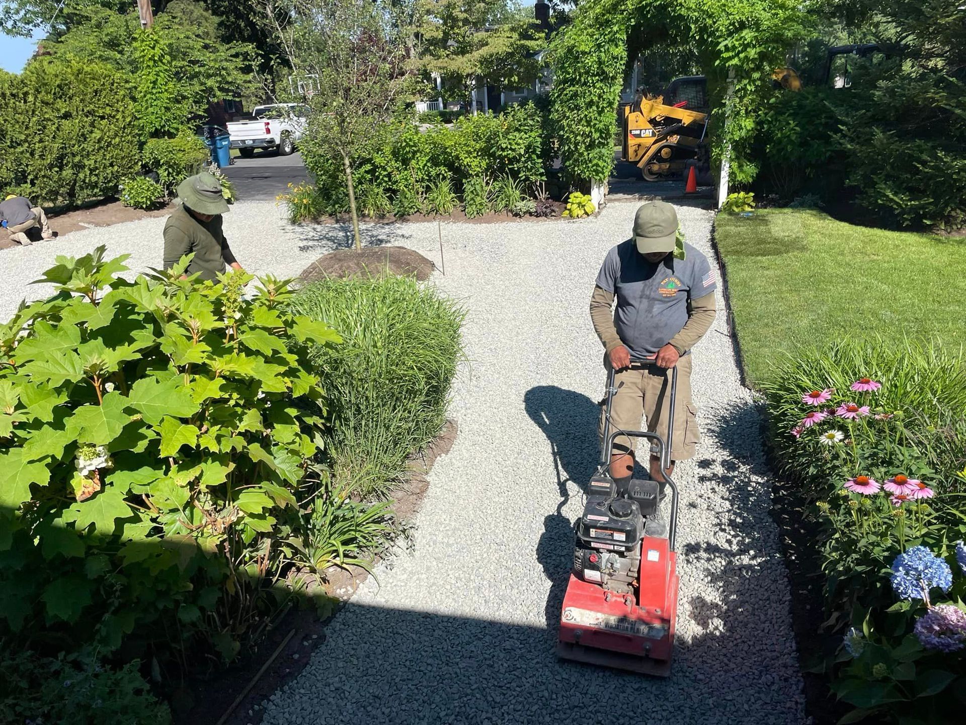 a man is using a machine to level a gravel driveway