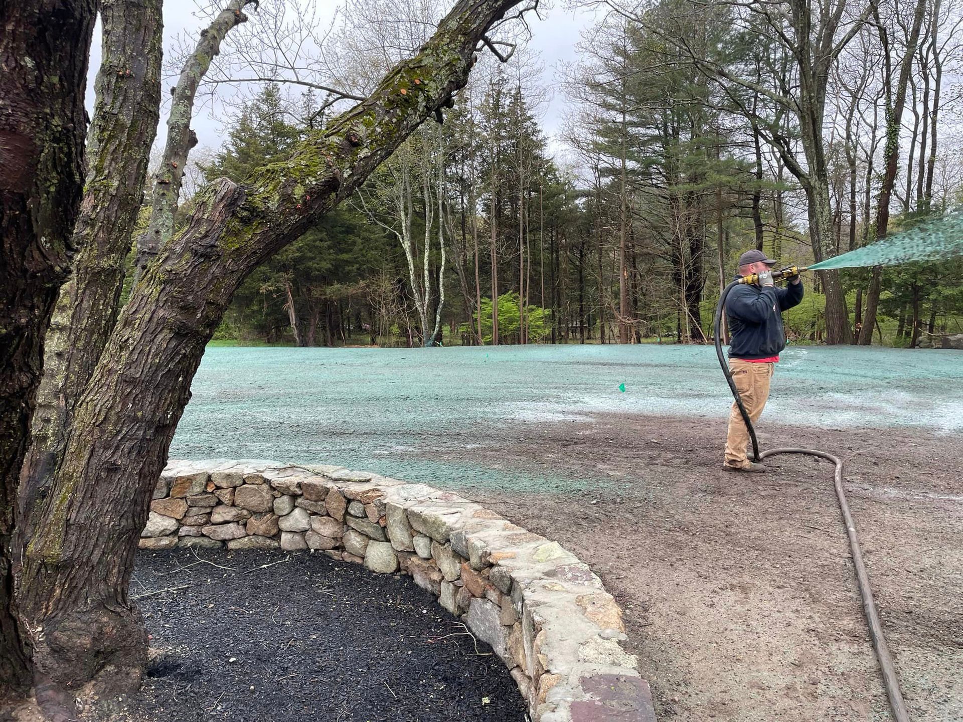 a man is standing in a field with a hose