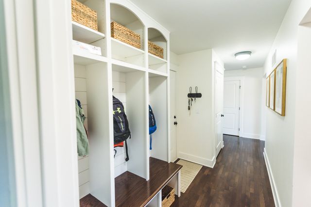 A hallway with a locker and a bench in it.