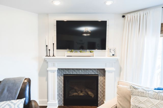 A living room with a fireplace and a flat screen tv.