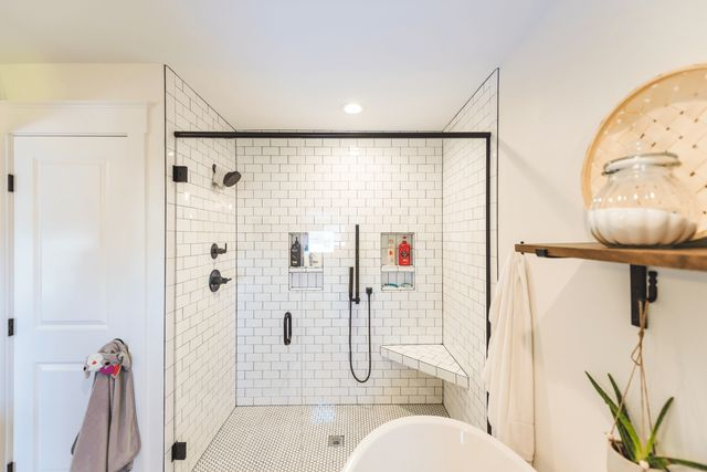 A bathroom with a walk in shower and a tub.