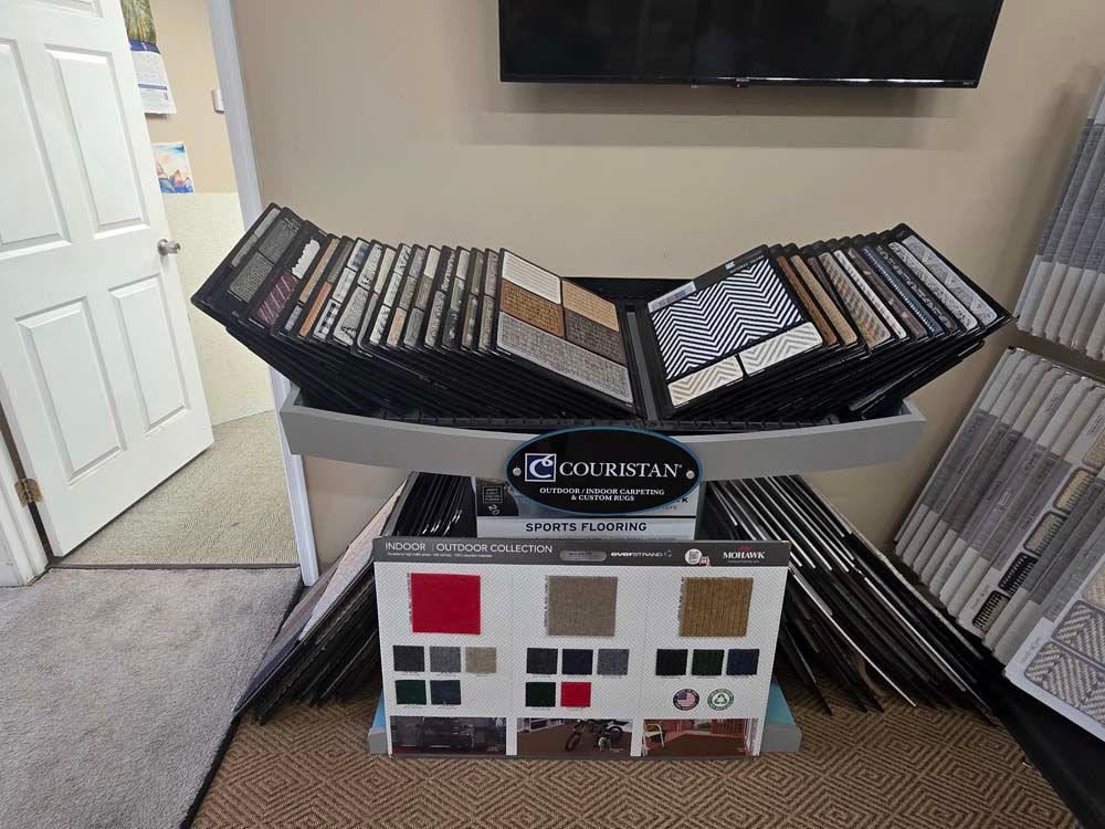 Tile samples displayed on a showroom stand, various colors and patterns.