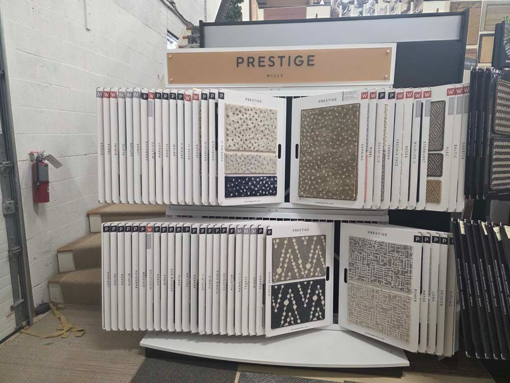 Carpet sample display in a showroom, showcasing various patterns and colors. 