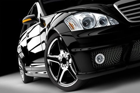 a close-up of a black car with chrome wheels on a black background
