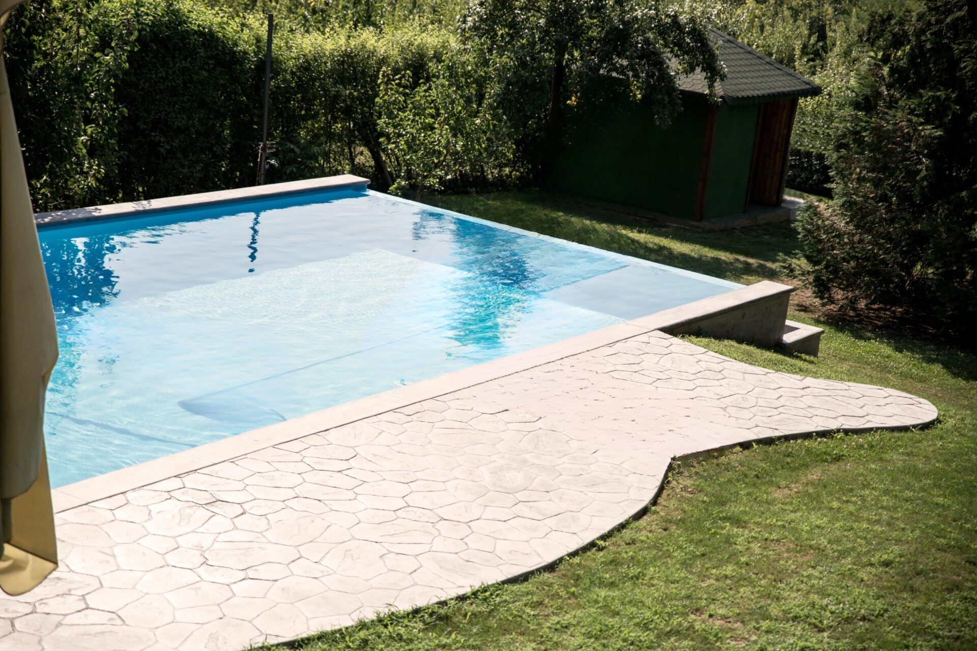 Eco-friendly pool design featuring a surrounding stone patio.