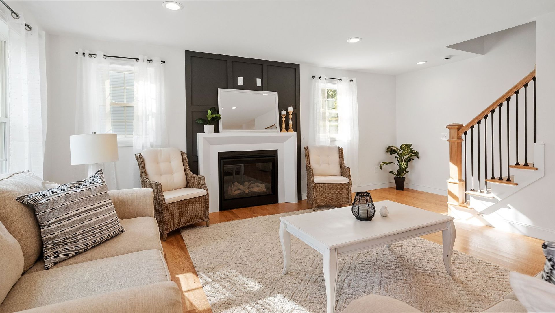 Cozy living room with fireplace, cream-colored sofa, and wood flooring.