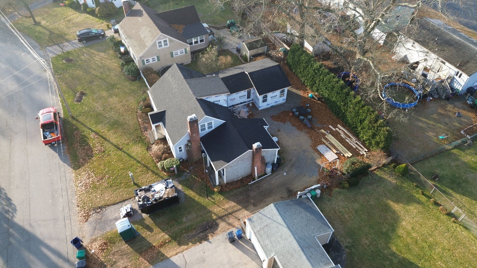 Overhead view of homes, a truck, and construction materials on a residential street.