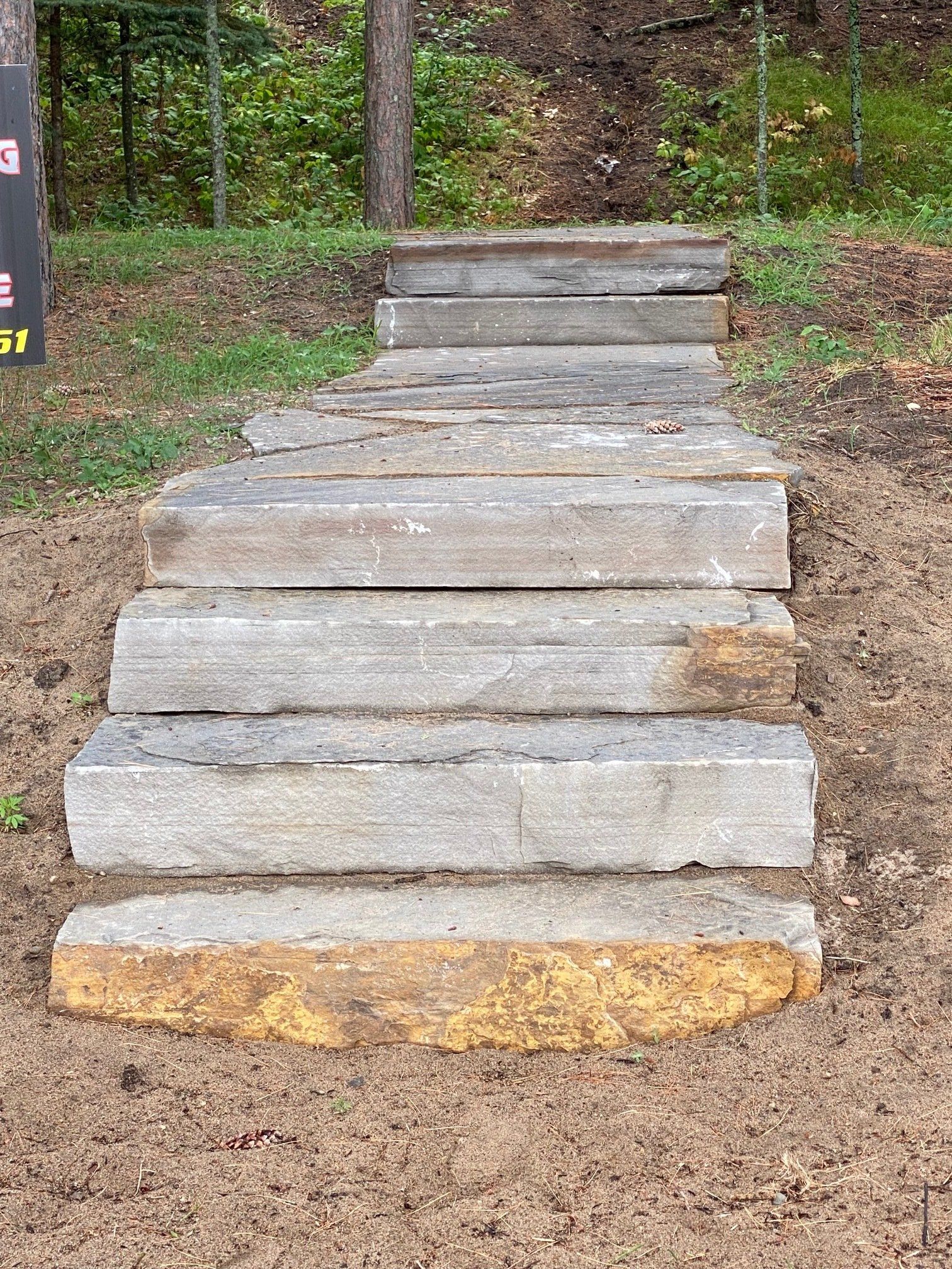 Stone steps leading upwards through dirt ground.