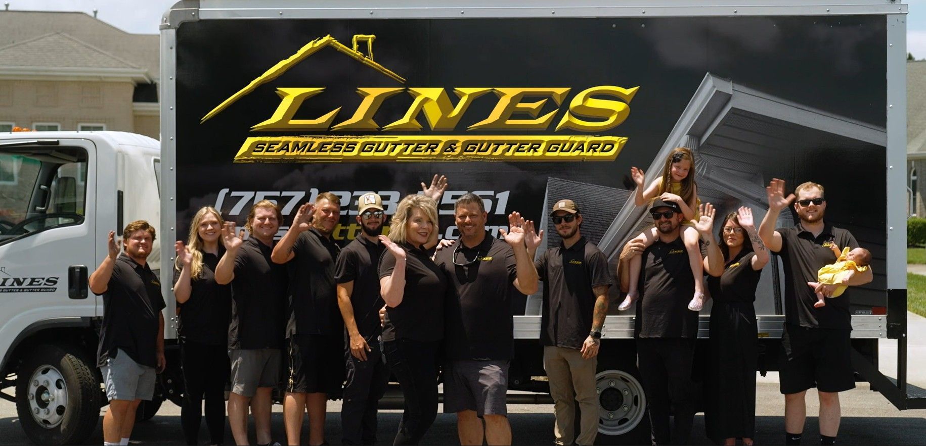 A woman with blonde hair in a black shirt smiling in front of a business logo.
