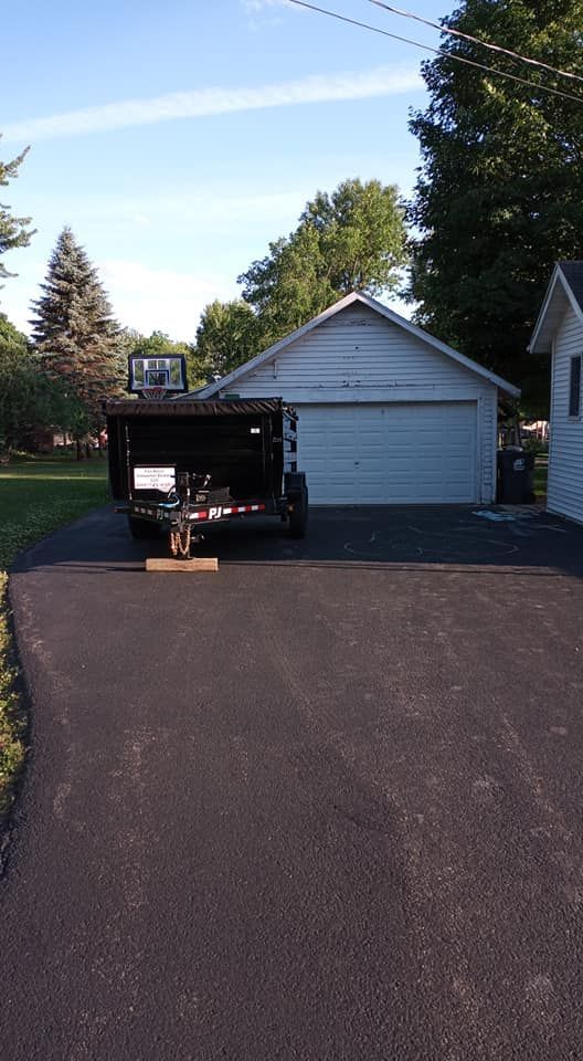 a dumpster is parked in a driveway next to a garage
